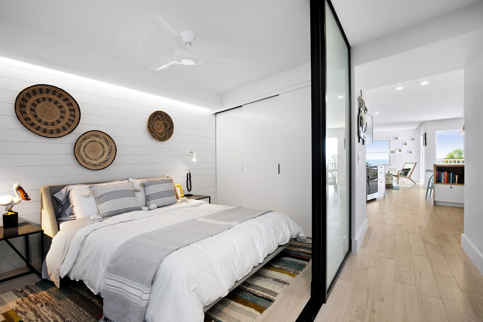 タンパにある小さなビーチスタイルのおしゃれな寝室 (白い壁、ベージュの床) のインテリア