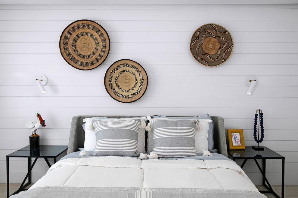 タンパにある小さなビーチスタイルのおしゃれなロフト寝室 (白い壁、セラミックタイルの床、ベージュの床) のインテリア