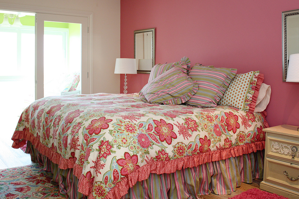 Example of a large beach style master light wood floor bedroom design in Tampa with pink walls and no fireplace