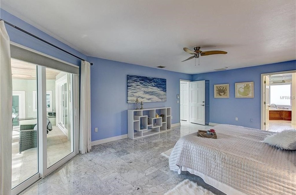 Imagen de dormitorio principal actual de tamaño medio sin chimenea con paredes azules y suelo de mármol
