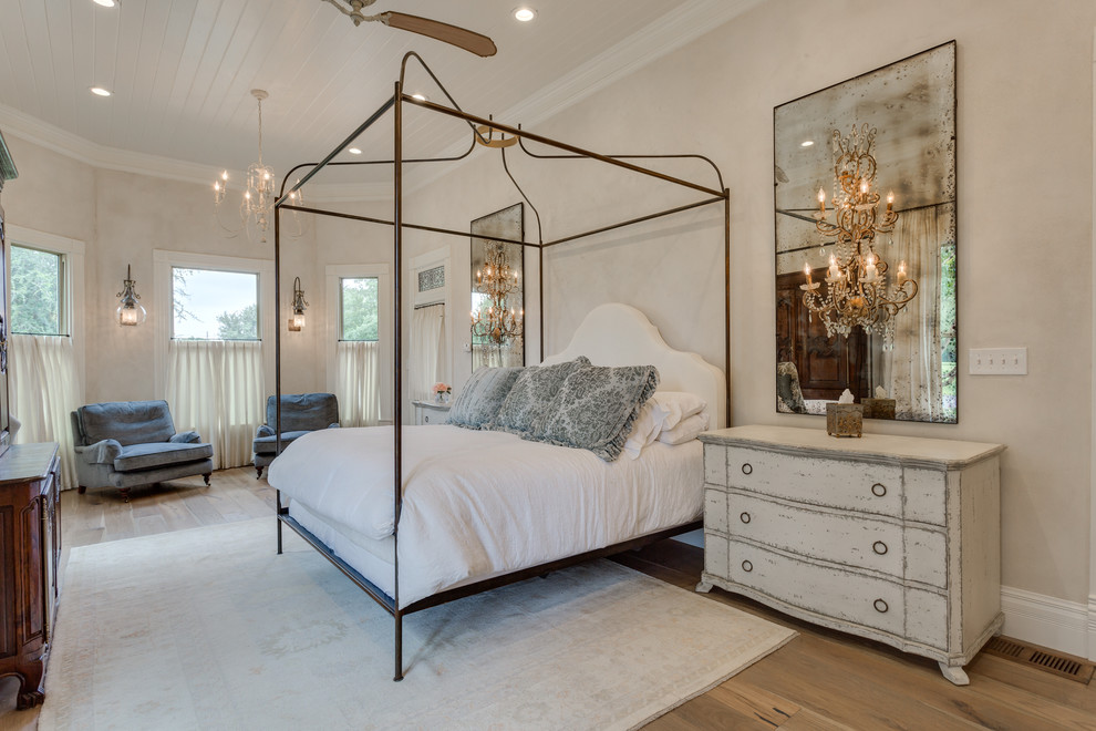 Modelo de dormitorio principal clásico de tamaño medio con paredes blancas, suelo de madera en tonos medios y suelo marrón