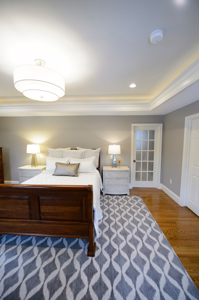 Inspiration for a large transitional master medium tone wood floor bedroom remodel in Boston with gray walls and no fireplace
