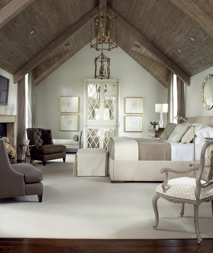 Cette image montre une grande chambre parentale traditionnelle avec un mur blanc, parquet foncé, une cheminée standard, un manteau de cheminée en pierre et un sol marron.