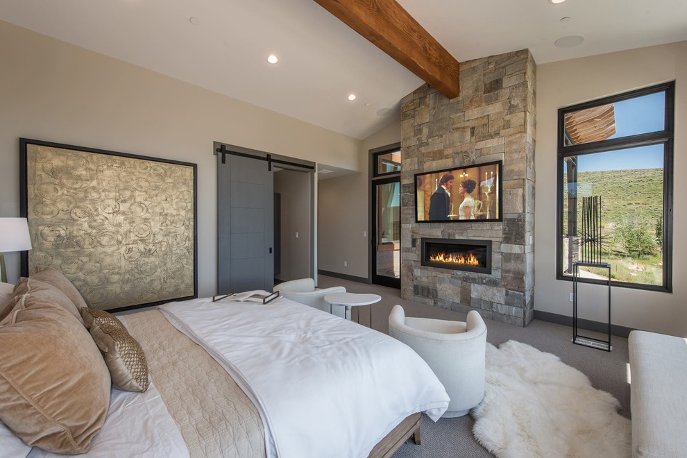 Пример оригинального дизайна: хозяйская спальня в стиле рустика с бежевыми стенами, ковровым покрытием, горизонтальным камином, фасадом камина из металла, серым полом и телевизором