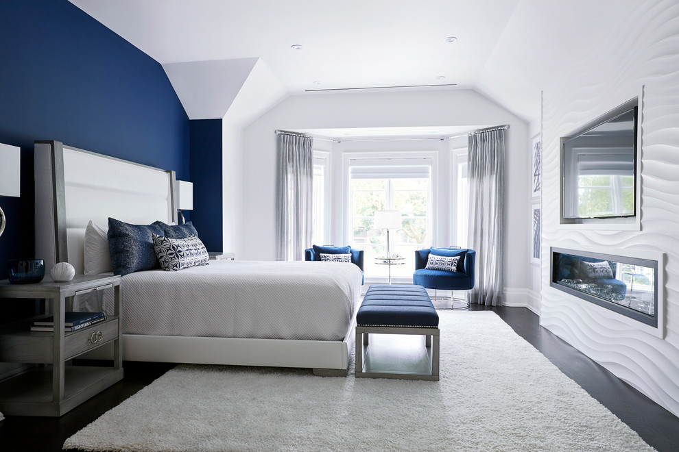 Foto de habitación de invitados clásica renovada grande con paredes azules, suelo de madera oscura y chimenea lineal