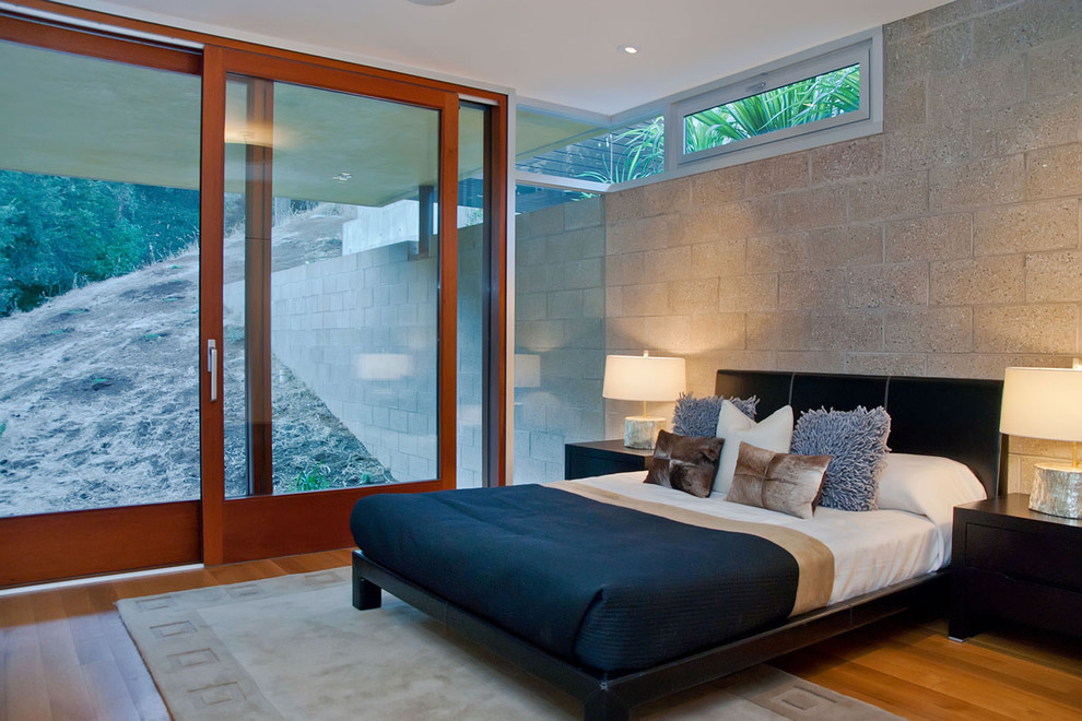 Foto di una camera da letto design con pavimento in legno massello medio