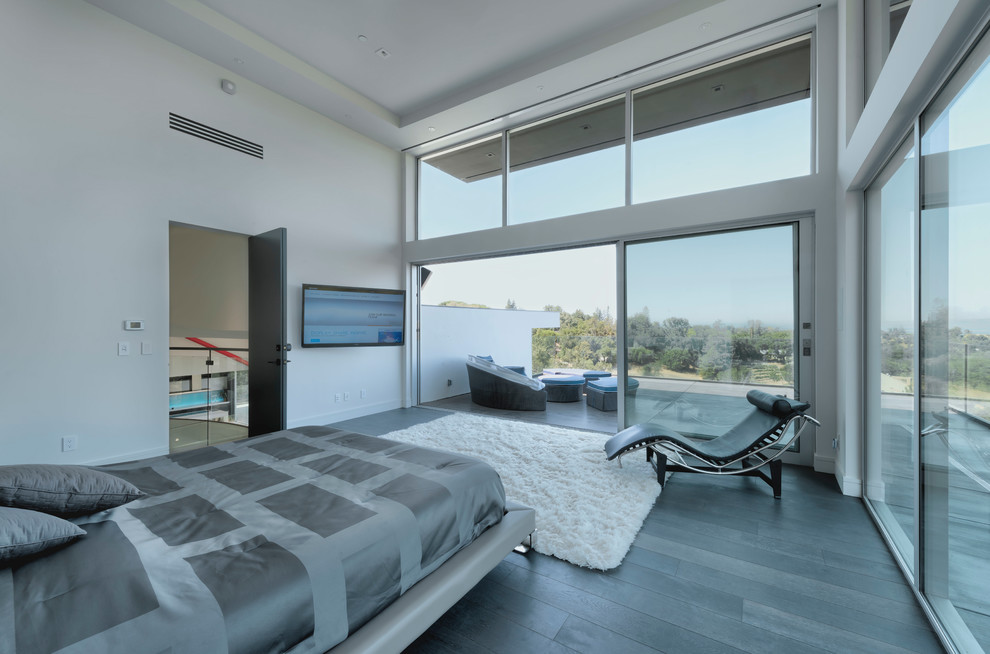 This is an example of a large contemporary master bedroom in San Francisco with white walls, dark hardwood flooring and grey floors.