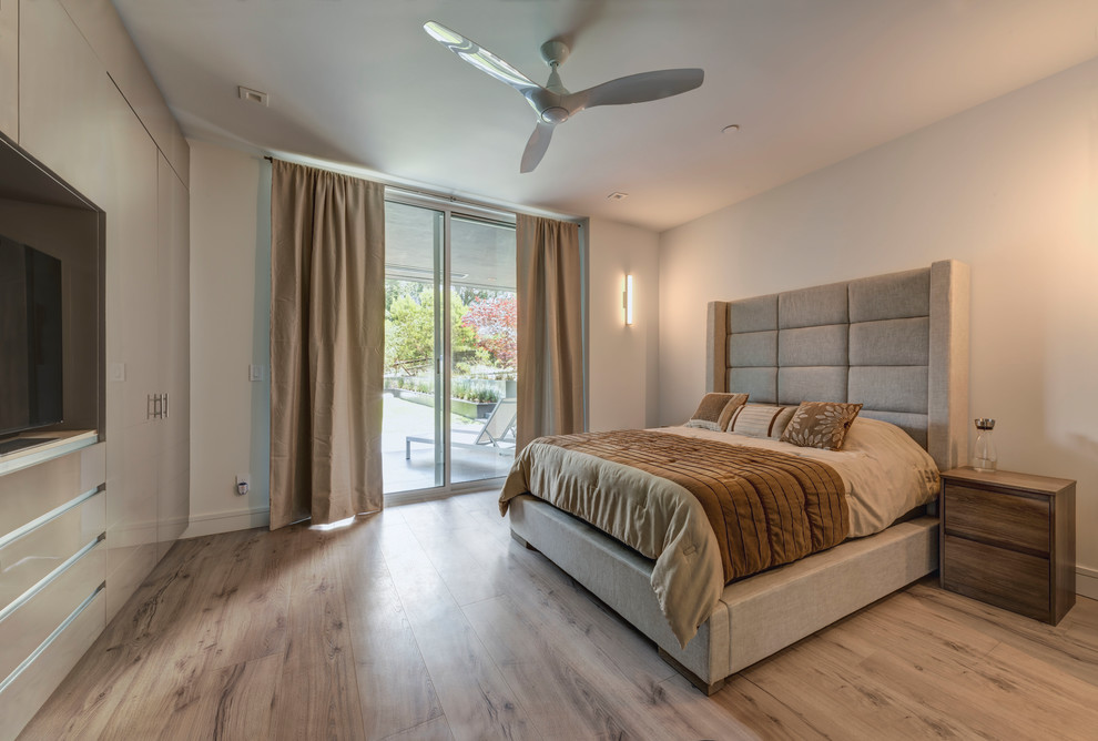 Imagen de habitación de invitados actual de tamaño medio con suelo de contrachapado, suelo beige y paredes blancas