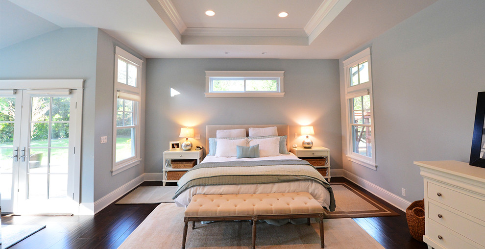 Modelo de dormitorio principal de estilo americano grande sin chimenea con paredes azules y suelo vinílico