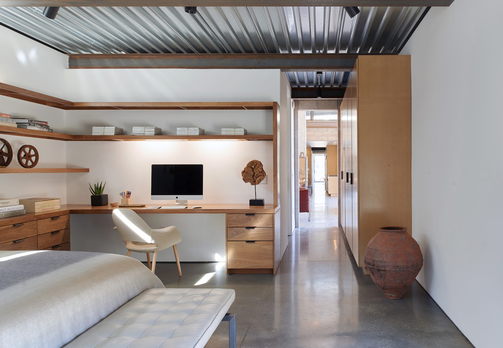 Urban bedroom in Los Angeles with white walls, concrete flooring and grey floors.