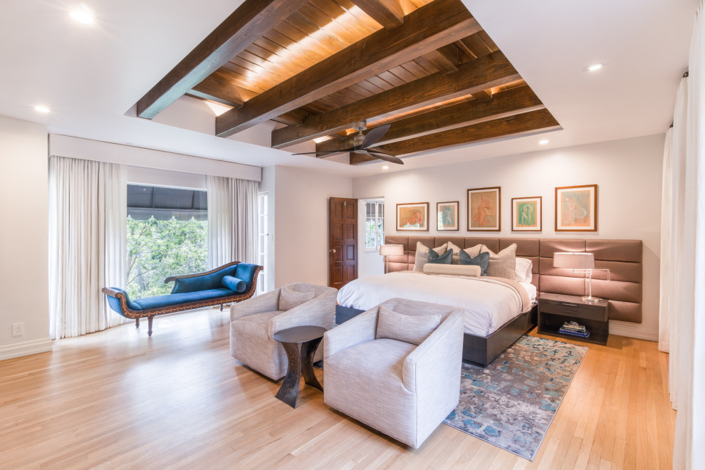 Imagen de dormitorio principal clásico renovado grande sin chimenea con paredes beige, suelo de madera en tonos medios, suelo marrón y vigas vistas
