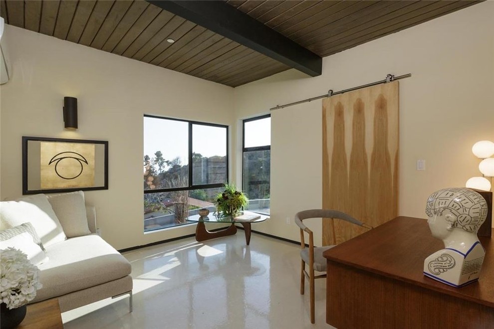 Cette photo montre une chambre d'amis moderne de taille moyenne avec un mur blanc, sol en stratifié et aucune cheminée.