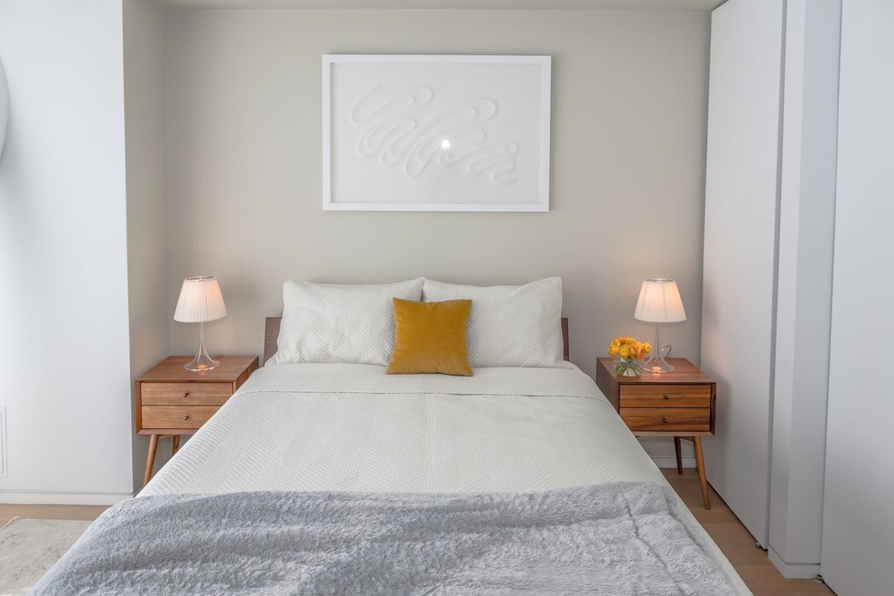 Ejemplo de dormitorio principal moderno de tamaño medio sin chimenea con paredes blancas y suelo de madera clara