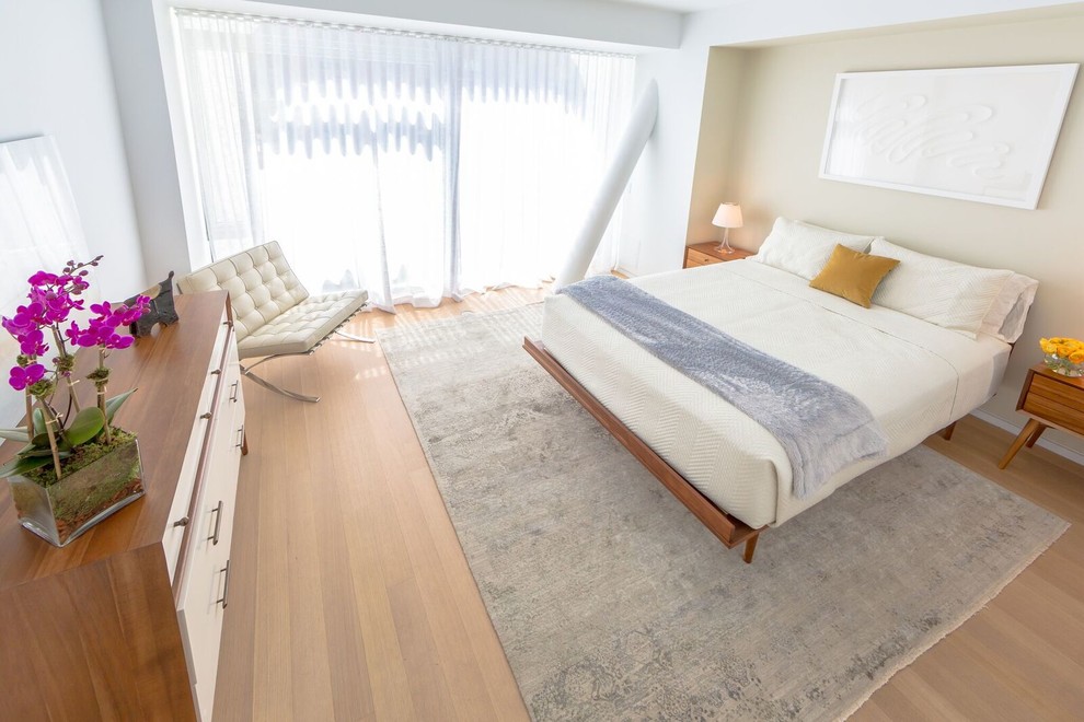 Diseño de dormitorio principal moderno de tamaño medio sin chimenea con paredes blancas y suelo de madera clara