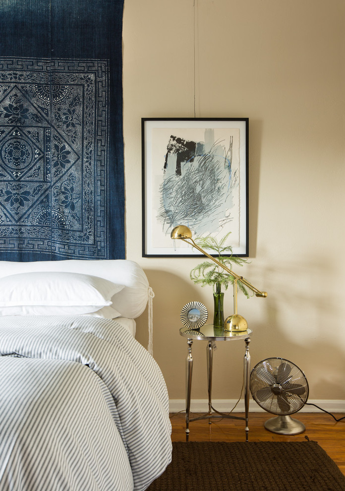 Diseño de dormitorio principal bohemio pequeño con paredes beige y suelo de madera en tonos medios