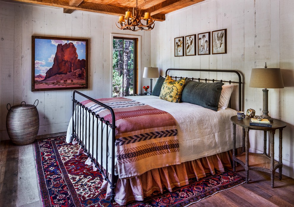Diseño de dormitorio rústico sin chimenea con suelo de madera en tonos medios