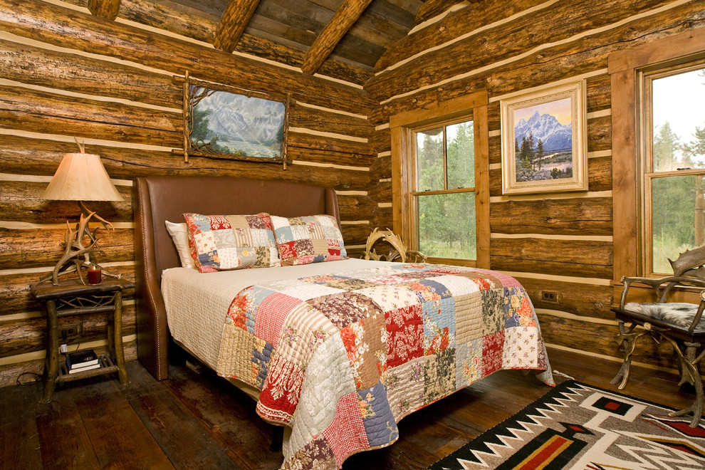 Imagen de dormitorio rural con suelo de madera oscura