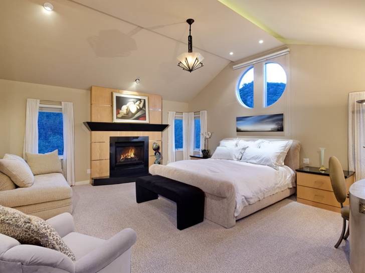 This is an example of a small modern master bedroom in Denver with beige walls, carpet, a standard fireplace and a stone fireplace surround.