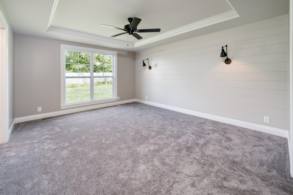 Landhaus Hauptschlafzimmer mit beiger Wandfarbe, Teppichboden, grauem Boden, eingelassener Decke und Holzdielenwänden in Huntington