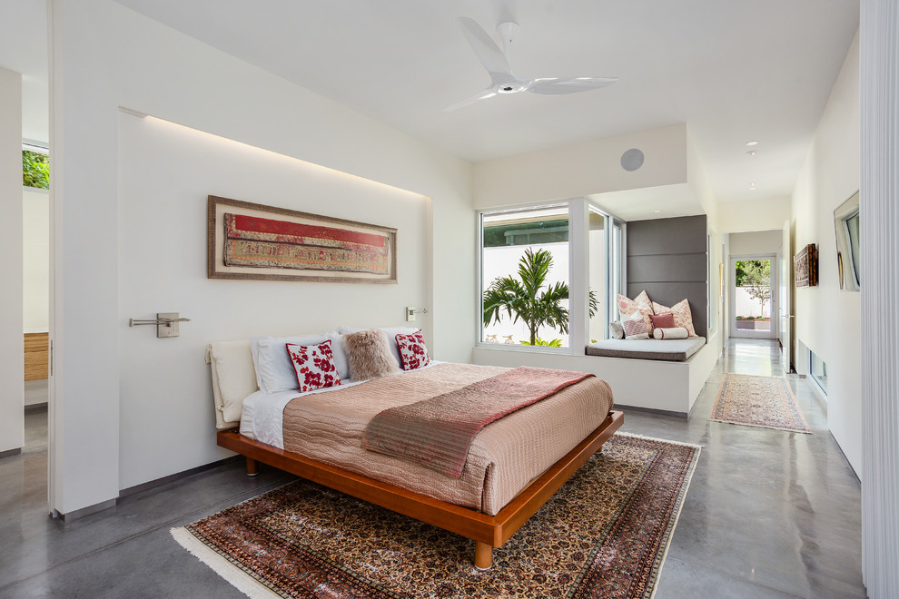 タンパにある中くらいなトロピカルスタイルのおしゃれな主寝室 (白い壁、コンクリートの床) のレイアウト