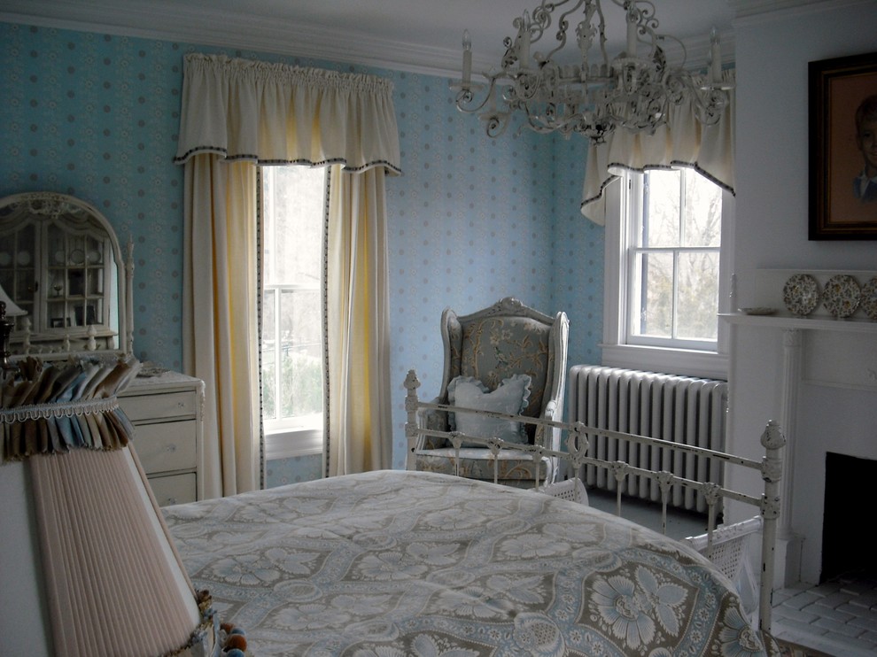 Immagine di una piccola camera degli ospiti classica con pareti blu, pavimento in legno verniciato, camino classico e cornice del camino in intonaco