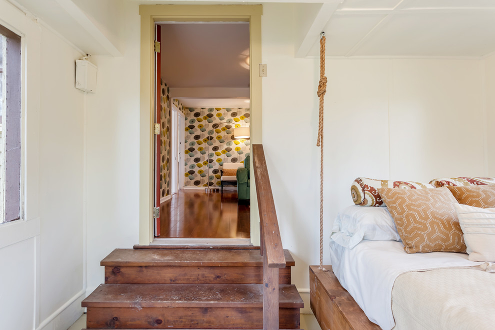 Ispirazione per una grande camera degli ospiti chic con pavimento in legno verniciato