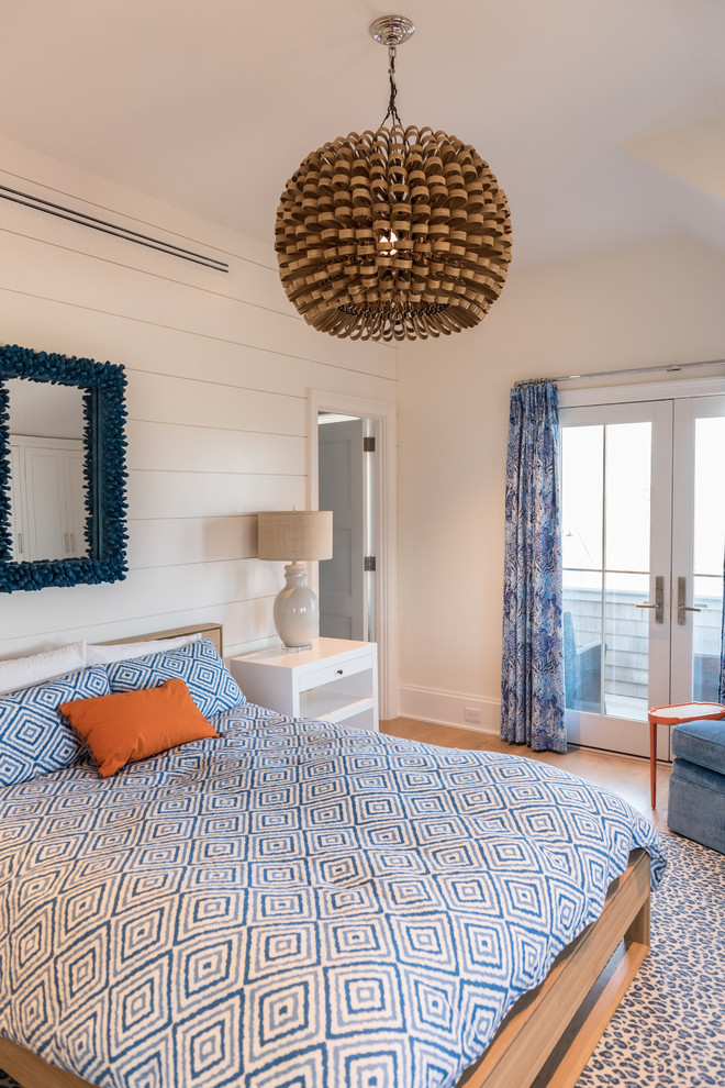 This is an example of a beach style bedroom in Other with white walls, light hardwood flooring and beige floors.