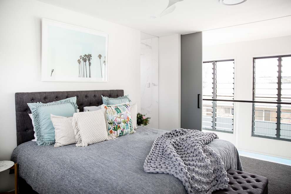 Modelo de dormitorio contemporáneo con paredes blancas, moqueta y suelo gris