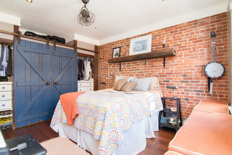 Kleines Stilmix Hauptschlafzimmer ohne Kamin mit braunem Holzboden in New York