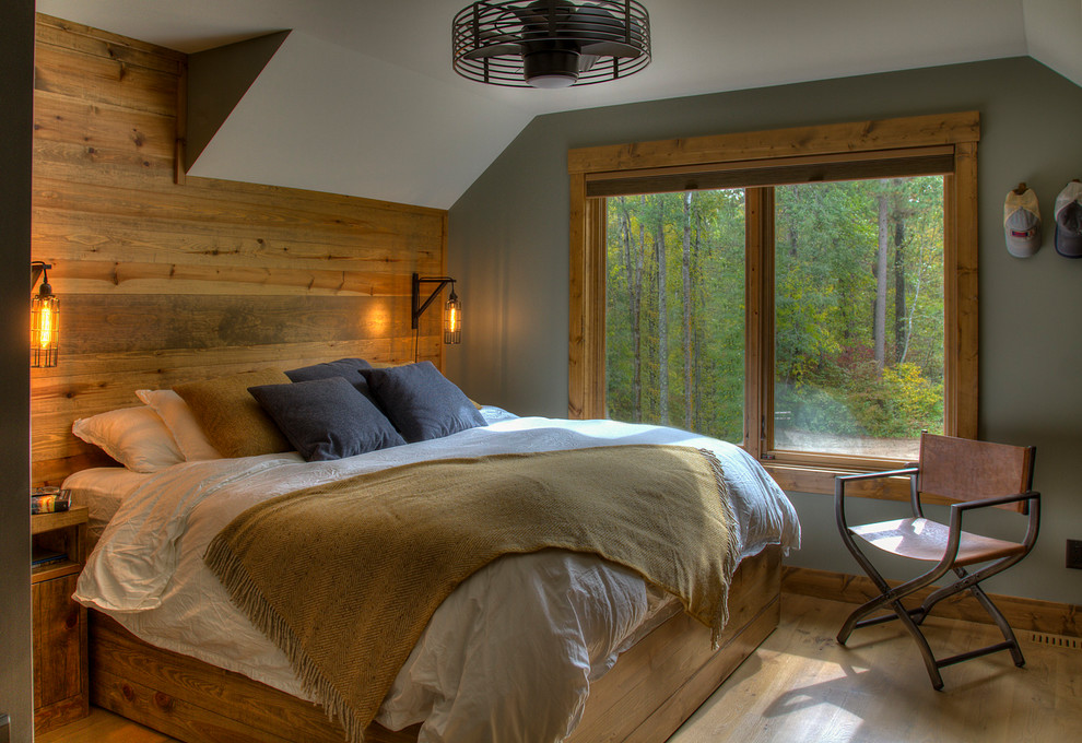 Imagen de dormitorio rural con paredes grises, suelo de madera en tonos medios y suelo marrón