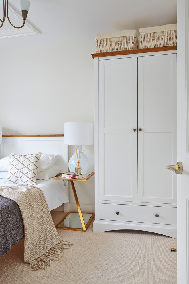 Country Schlafzimmer mit weißer Wandfarbe, Teppichboden und beigem Boden in London