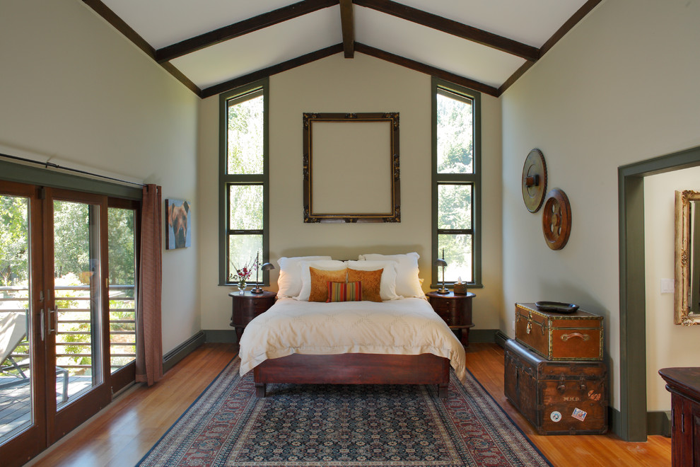 Cette image montre une chambre bohème avec un mur blanc et un sol en bois brun.