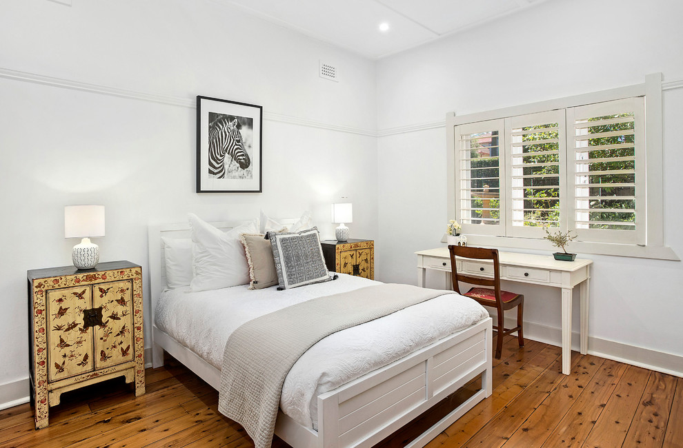 Inspiration for a mid-sized transitional master medium tone wood floor bedroom remodel in Sydney with white walls