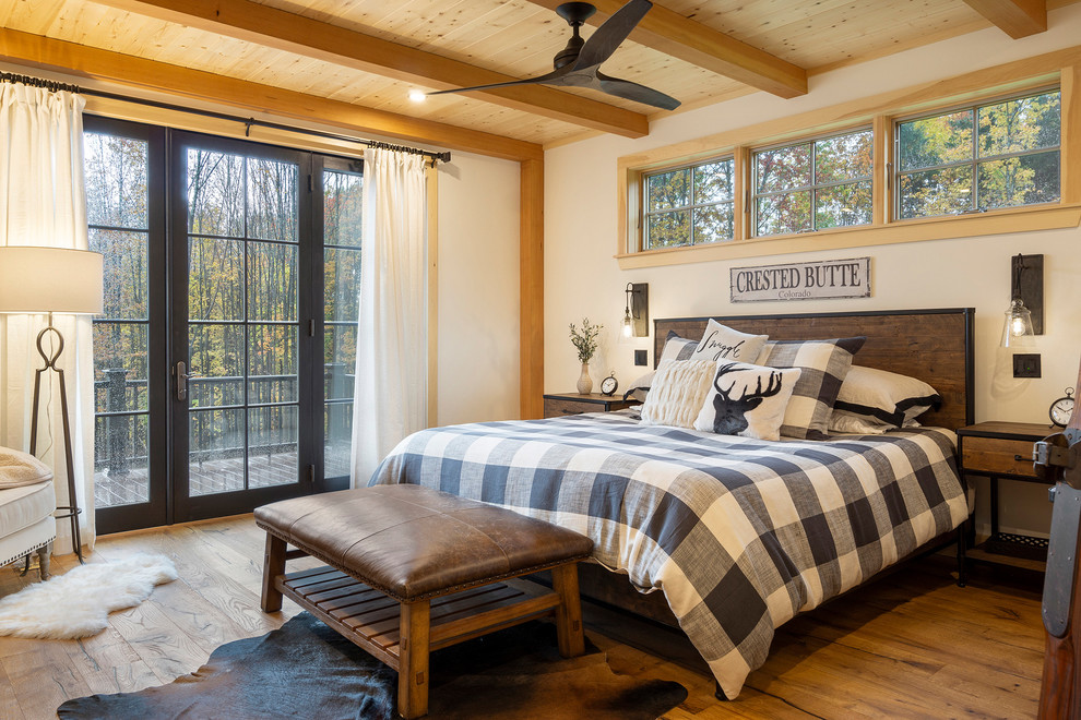 Foto de dormitorio principal rústico grande sin chimenea con paredes blancas, suelo de madera en tonos medios y suelo marrón