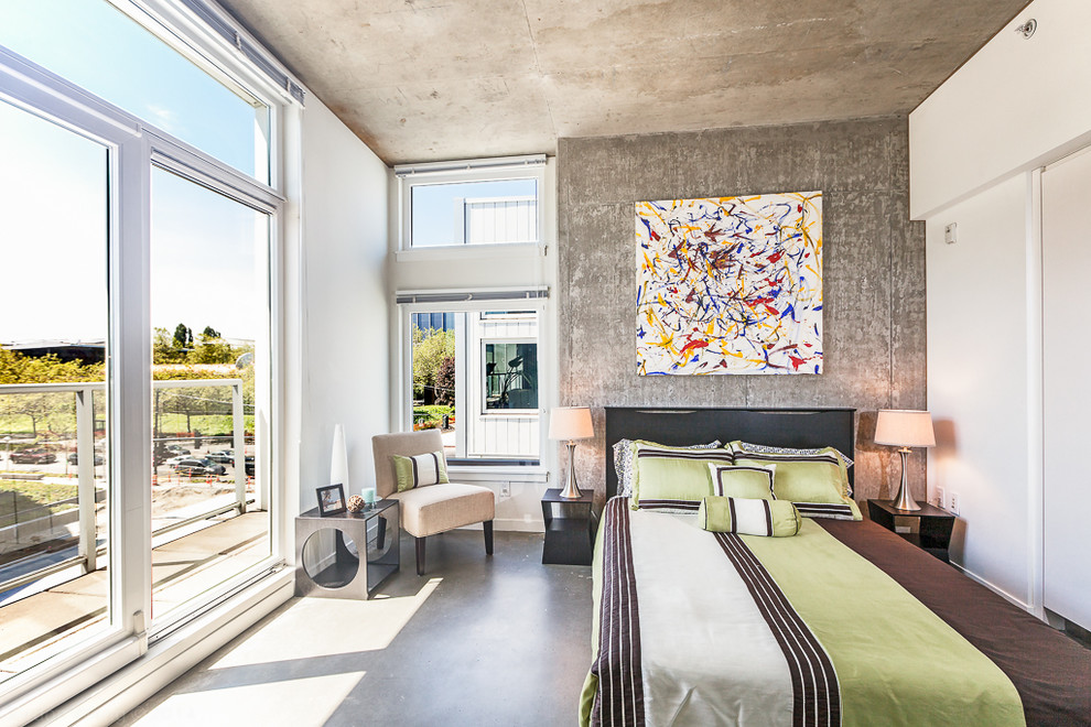 Imagen de dormitorio principal urbano de tamaño medio con paredes grises y suelo de cemento
