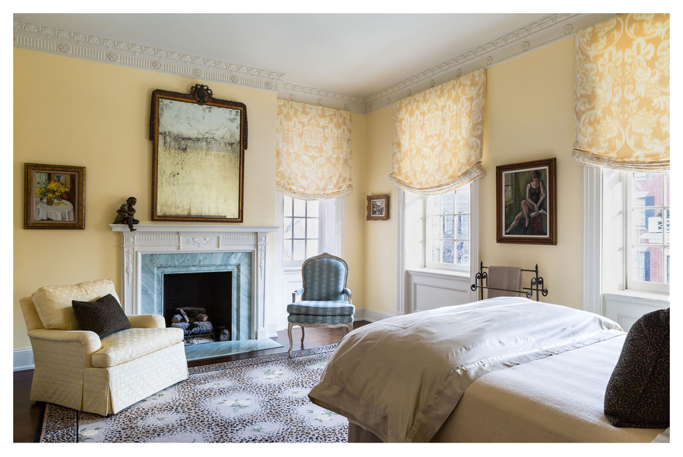 ワシントンD.C.にある広いトラディショナルスタイルのおしゃれな客用寝室 (黄色い壁、標準型暖炉、石材の暖炉まわり、濃色無垢フローリング、茶色い床) のインテリア