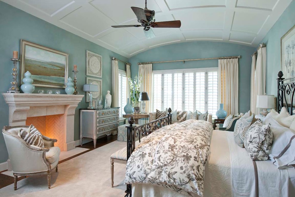 На фото: спальня в классическом стиле с синими стенами и стандартным камином с