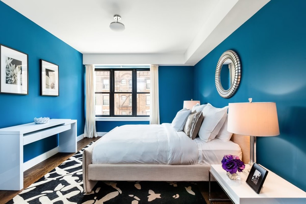 На фото: хозяйская спальня среднего размера в современном стиле с синими стенами и темным паркетным полом