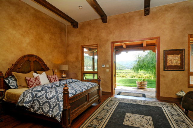 Imagen de dormitorio principal mediterráneo de tamaño medio sin chimenea con paredes multicolor y suelo de madera en tonos medios