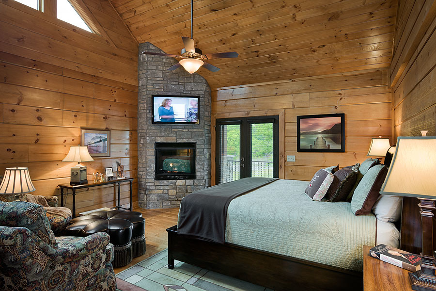 他の地域にある中くらいなトランジショナルスタイルのおしゃれな主寝室 (茶色い壁、淡色無垢フローリング、コーナー設置型暖炉、石材の暖炉まわり) のレイアウト