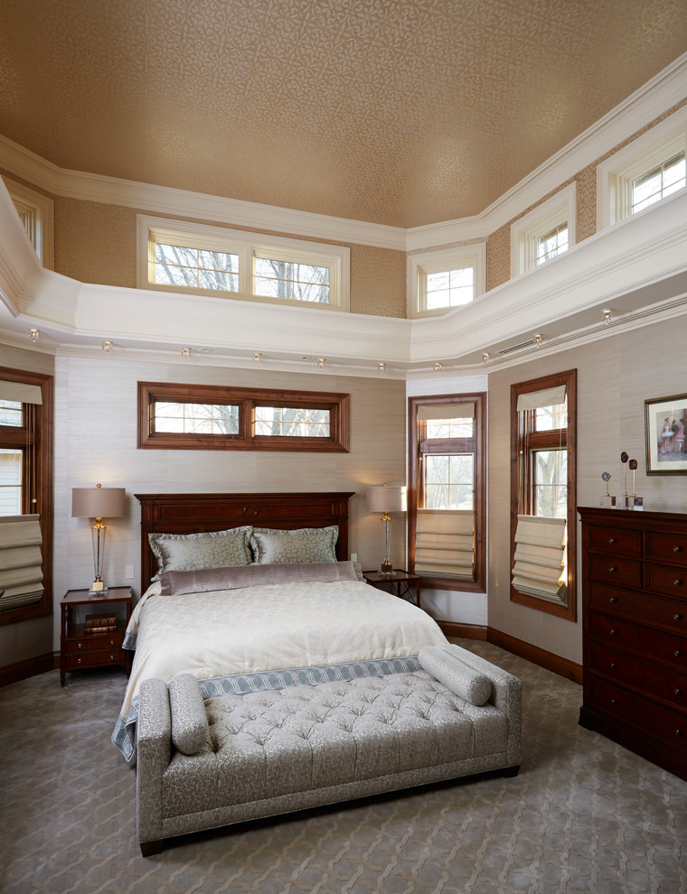 На фото: большая хозяйская спальня в классическом стиле с ковровым покрытием, бежевыми стенами и серым полом без камина