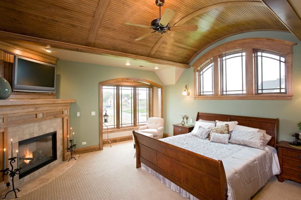 Large traditional master bedroom in Chicago with green walls, carpet, a corner fireplace and a tiled fireplace surround.
