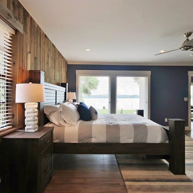 Inspiration for a large rustic medium tone wood floor and brown floor bedroom remodel in Charlotte with brown walls and no fireplace