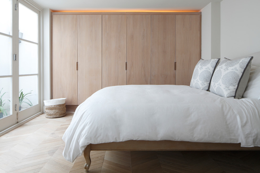 Inspiration för stora moderna gästrum, med vita väggar, ljust trägolv och brunt golv