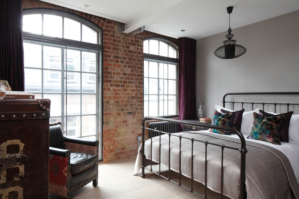 Design ideas for a medium sized industrial guest bedroom in London with grey walls.