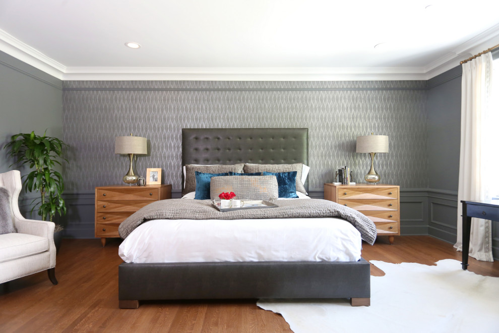 Imagen de dormitorio principal clásico renovado grande con paredes grises, suelo de madera en tonos medios, todas las chimeneas, marco de chimenea de piedra y suelo marrón
