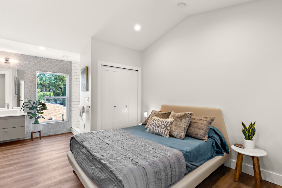 Diseño de dormitorio tipo loft actual de tamaño medio con paredes grises y suelo vinílico