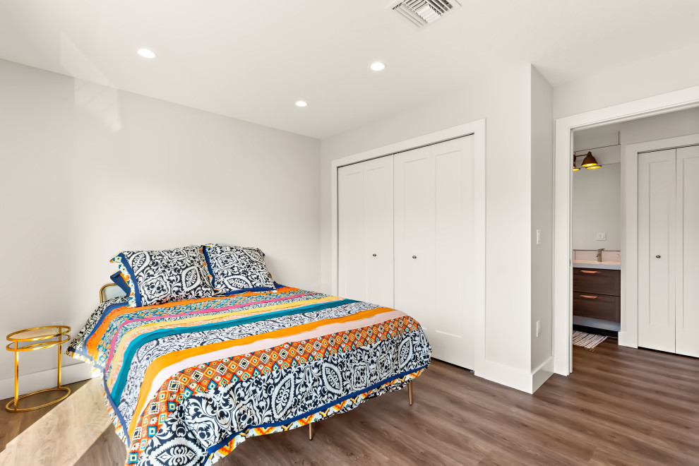 Modelo de dormitorio tipo loft ecléctico de tamaño medio con paredes grises y suelo vinílico