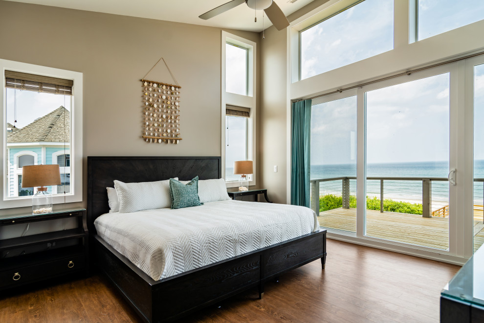 На фото: огромная хозяйская спальня в морском стиле с бежевыми стенами, паркетным полом среднего тона и коричневым полом без камина