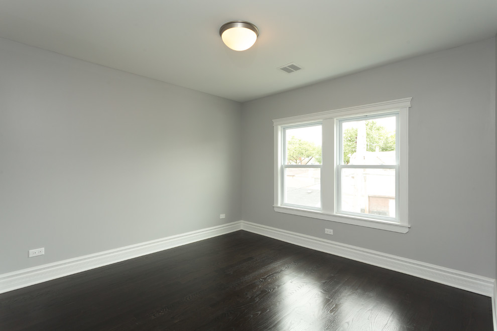 Immagine di una camera da letto minimal di medie dimensioni con pareti grigie, parquet scuro, nessun camino e pavimento marrone